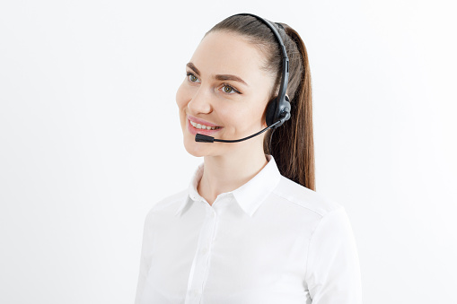 Portrait o female customer support or sales agent working in row with her colleagues at call center office. Business, technology, internet and network concept.