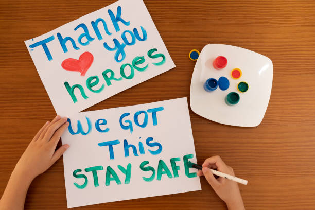fermez la main de l’enfant écrivant des messages positifs aux héros de première ligne travaillant pendant la quarantaine de coronavirus (covid-19). - heroes photos et images de collection