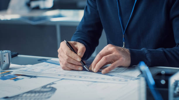 istock Heavy Industry Engineer Draws Engine Concept Blueprint. Engineering Bureau and Industrial Design Agency with Various Robotic, Architectural and Machinery Components 1217883748