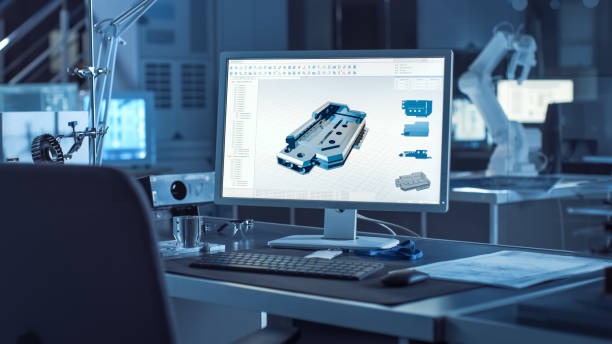 istock On the Desk Computer With CAD Software and Design of 3D Industrial Machinery Component. In the Background Robot Arm Concept Standing in Heavy the Dark.Industry Engineering Facility. 1217883753