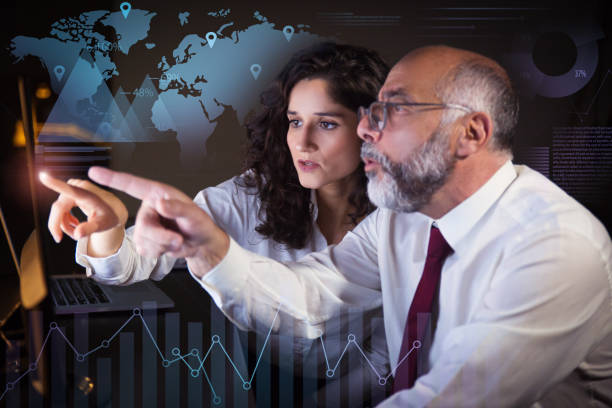 istock Coworkers pointing at monitor and virtual statistic graphics 1217883882