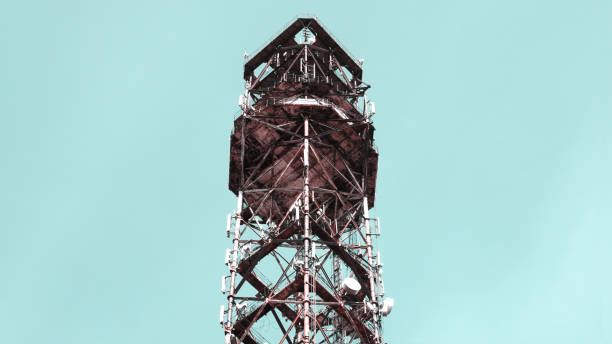 Old rust abandoned radio tower close up against the blue sky. Creative photo in pastel colours for advertising wallpapers news posters