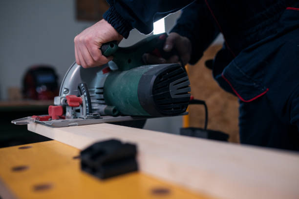 istock Carpenter sawing wood plank with saw 1217895017