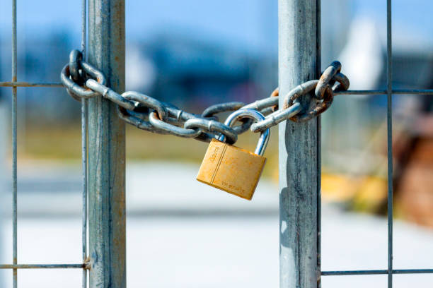 istock Closed gate with metal chain and padlock,  background with copy space 1217895037