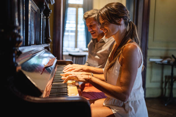 istock Beautiful couple of pianists playing a piano at home 1217897708