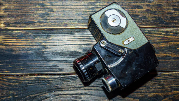 istock Vintage old movie camera on the wooden table. Space for text. 1217897770