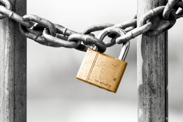 istock Closed gate with metal chain and padlock,  background with copy space 1217900067