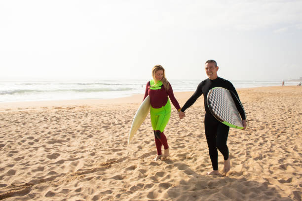 istock Happy couple holding hands and walking at beach together 1217901247