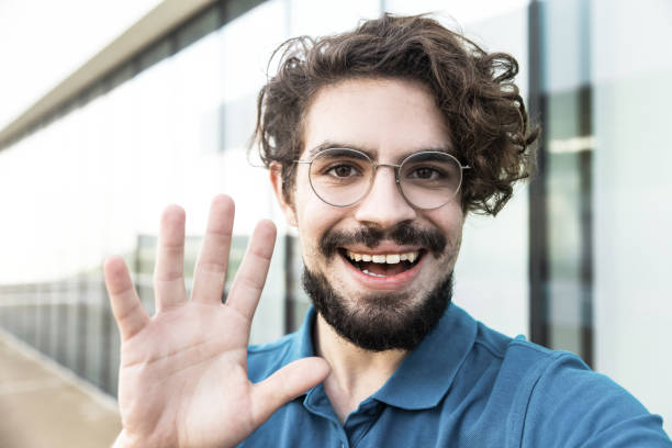 istock Happy cheerful guy wearing glasses, waving hello 1217901939