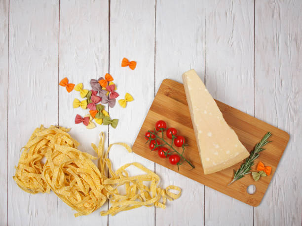 massa italiana seca fettuccini e farfalle com tomates, queijo e alecrim - bow tie pasta italian cuisine bow heap - fotografias e filmes do acervo