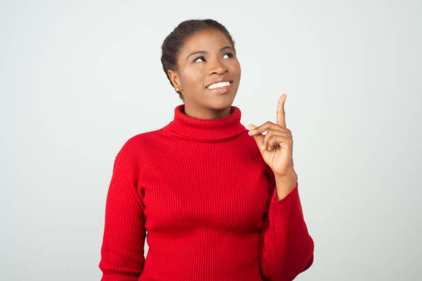 istock Happy joyful black lady pointing index finger up 1217904593