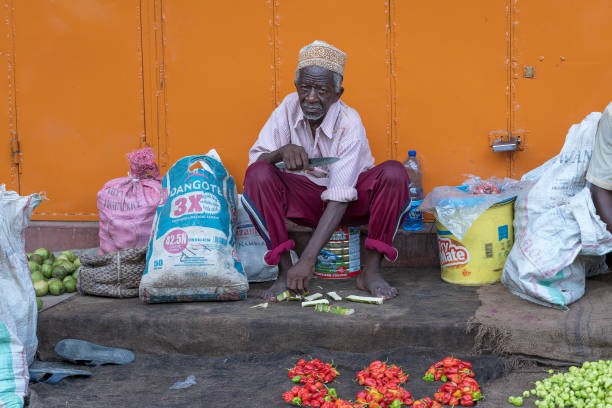 африканский старик продает овощи на местном рынке уличной еды на острове занзибар, танзания, восточная африка - africa agriculture zanzibar industry стоковые фото и изображения