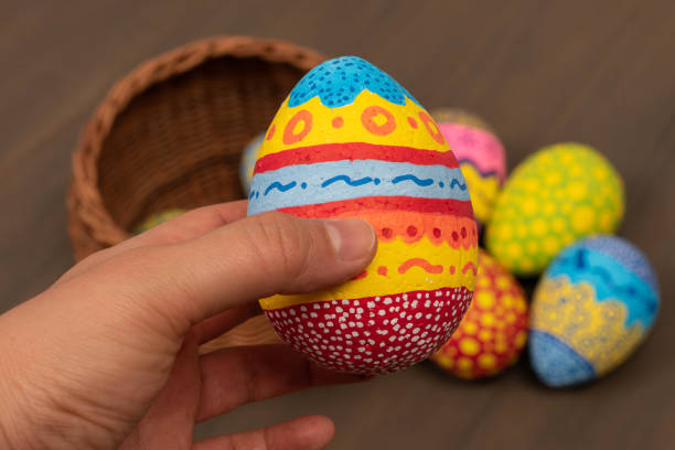 istock Woman hand holding a hand painted Easter egg 1217911799