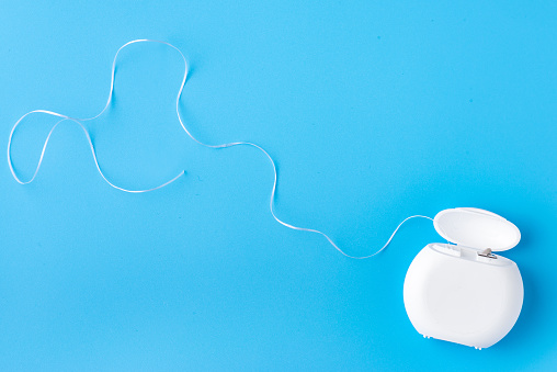 Dental floss on a blue background. Free space for text. Beautiful photo