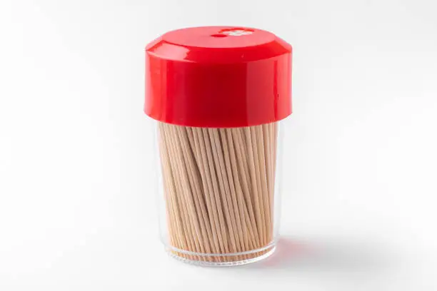 Photo of Toothpicks in a box on a white background. Closed bottle with toothpicks