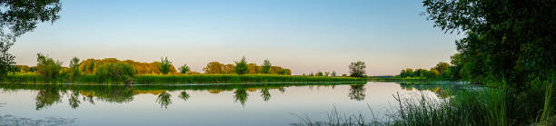 istock Panorama of a small quiet river against the forest 1217921275
