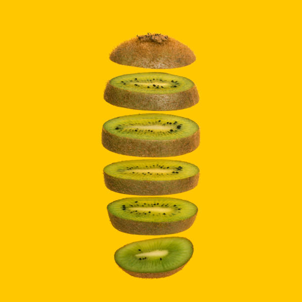 istock Creative concept with flying kiwi. Sliced kiwi isolated on yellow background. Levity fruit floating in the air 1217922409