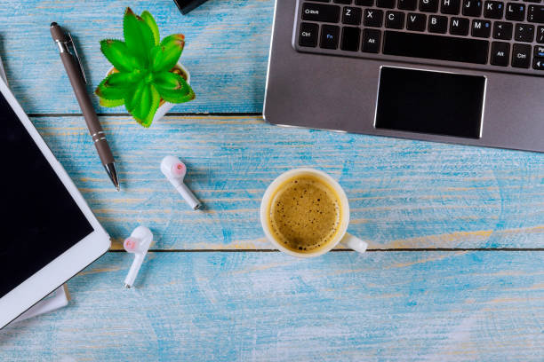 istock Freelance home office work with digital tablet laptop computer wireless headphones in coffee cup of espresso 1217926607