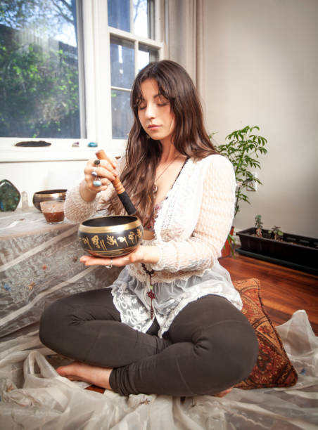 istock Beautiful Young Woman Meditating with Singing Bowl 1217927717