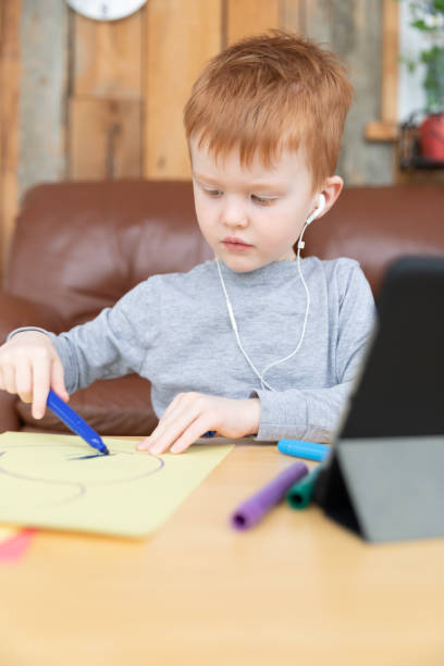istock Little redhead boy drawing with digital tablet 1217928295