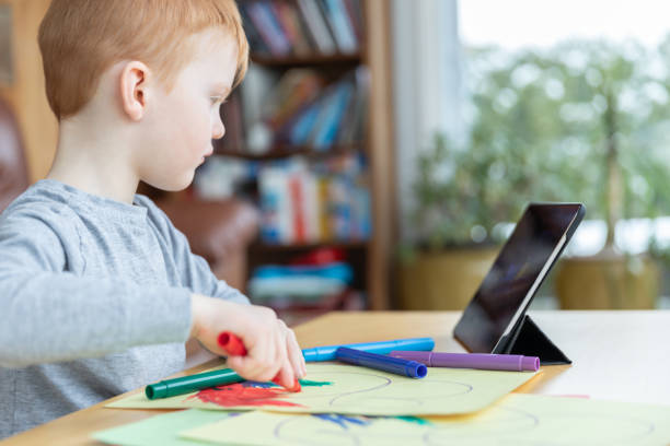 istock Little redhead boy drawing with digital tablet 1217928308