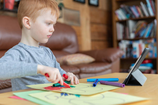 istock Little redhead boy drawing with digital tablet 1217928311