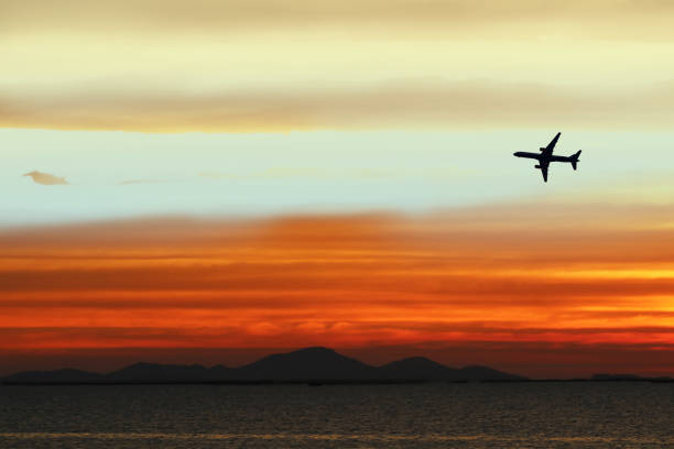 istock silhouette airplane on sky in sunset back on cloud white orange yellow red color 1217928541