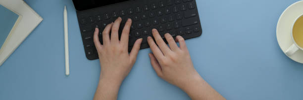 istock Overhead shot of female freelancer typing on digital tablet on light blue table 1217931671