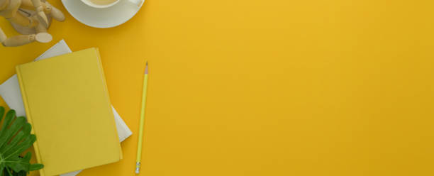 Top view of creative workspace with diary notebooks, tea cup, decoration and copy space