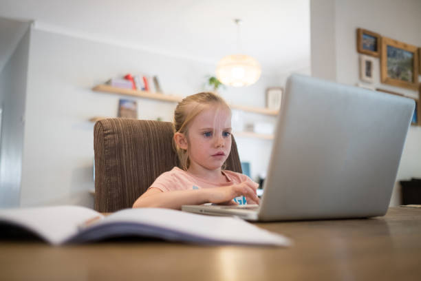 istock Little girl homeschooling on a laptop computer 1217932291