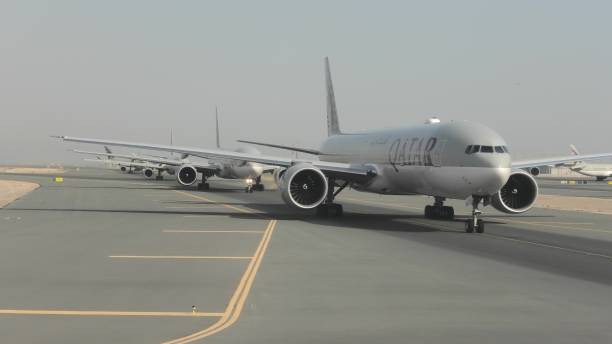 Doha, Qatar - February 24, 2019: Qatar Airways airplanes in queue waiting on the runway for taking off. Hamad International Airport of Doha city of Qatar, Persian Gulf.