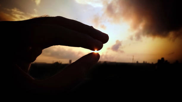 istock Beautiful sunrise holding the sun in hand with creativity 1217939508
