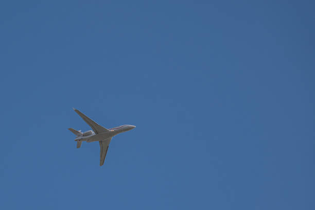 istock small white jet airplane flies in the blue almost cloudless sky 1217939565
