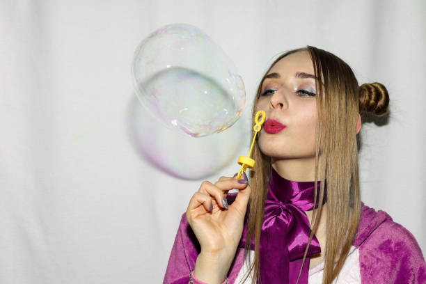 istock Cute girl with pigtails blowing soap bubbles 1217940354