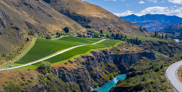 Aerial shoot of Chard Farm Vineyard set in the mountains beside winding river.