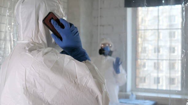 istock One doctor in protective suit making a serious call while anothe 1217942434