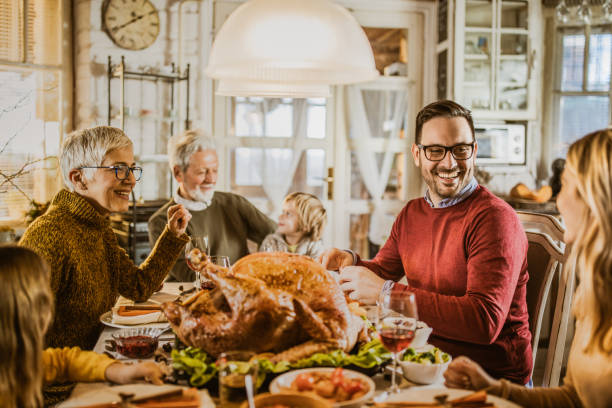 istock Happy extended family talking during Thanksgiving meal at dining table. 1217942445