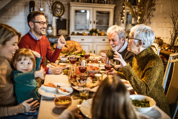 istock Happy multi-generation family communicating while having Thanksgiving lunch in dining room. 1217943232