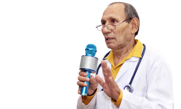старший врач-медик, держащий микрофон - new delhi audio стоковые фото и изображения
