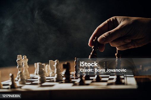istock Close up of hands of men playing chess. 1217948304