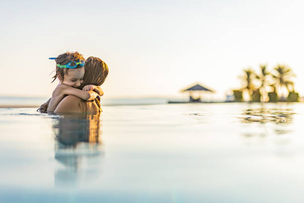 istock Happy boy embracing his single mother in the pool. 1217948591