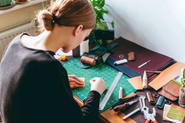 istock Woman making leather accessories at home 1217949279
