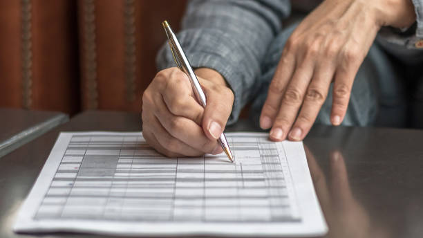 Administrator's hand fill in business schedule form document writing on yearly work plan, monthly timetable sheet, or weekly time table paper for office tasks, things and jobs to do list la mano del administrador rellena el formulario de horario de negocios que escribe en el plan de trabajo anual, la hoja de horarios mensuales o el papel semanal de la tabla de tiempo para las tareas de la oficina, las cosas y los trabajos que se pueden hac