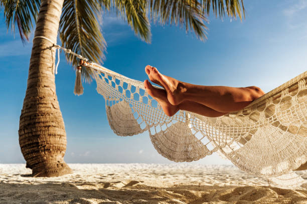 istock Unrecognizable woman's legs from a hammock on the beach. 1217951771