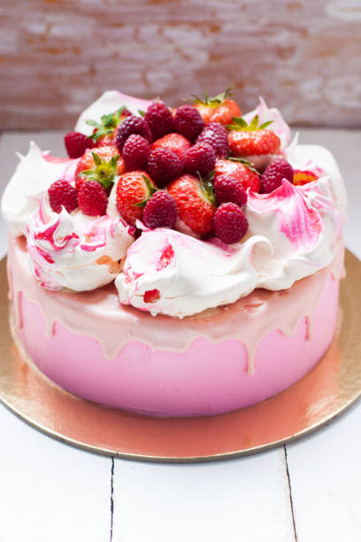 istock Pink cake with meringue, melted chocolate and fresh raspberries and strawberries. 1217951828