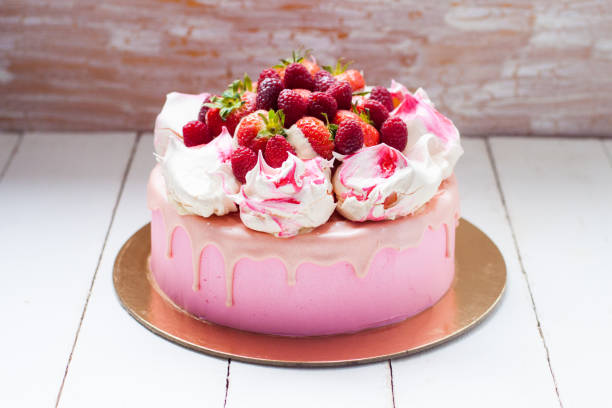 istock Pink cake with meringue, melted chocolate and fresh raspberries and strawberries. 1217951840