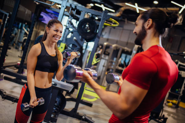 istock Dumbbell workout with personal trainer at gym 1217951935