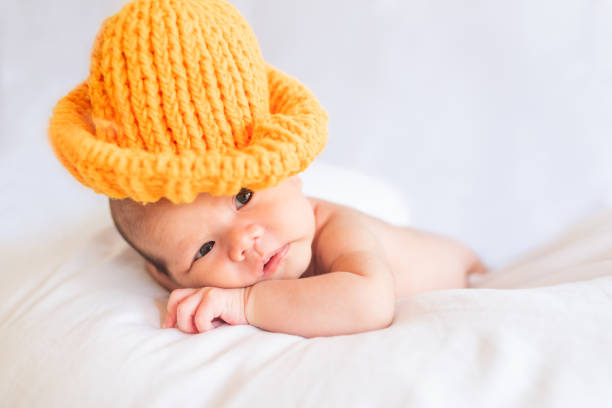 istock Little cute baby boy lying on the bed with a knitted hat 1217953407