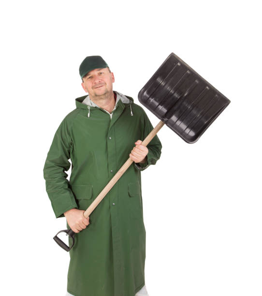istock A man in a long protective coat with a shovel. 1217954346