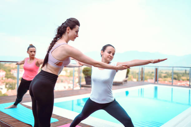 istock Female Yoga Teacher Correcting Her Student's Position 1217954377